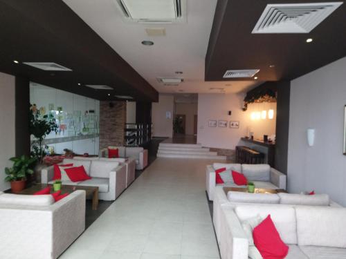 a lobby with white couches and red pillows at Studio L006 in Aspen Golf in Bansko