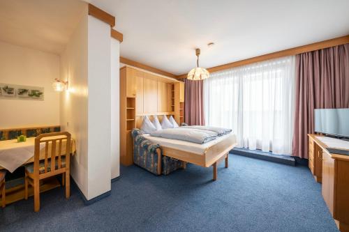 a hotel room with a bed and a television at Frühstückspension-Appartementhaus Wasserer in Bad Kleinkirchheim