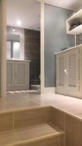 a large kitchen with white cabinets and a mirror at Le Nid Douillet in Sfax
