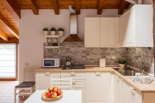 una cucina con armadi bianchi e un cesto di frutta di T-Rooftop a Como