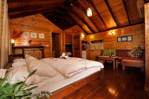 a bedroom with a large bed in a wooden room at Noa'm Bagalil in Peqi‘in H̱adasha