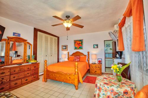 a bedroom with a bed, desk, and chair at Coconut Palms Inn in Rincon