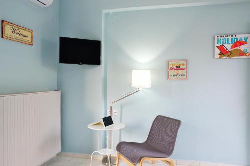 a blue room with a chair and a lamp at Katerina Apartments in Kato Daratso