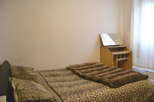 a bedroom with a bed and a table with a laptop at Superb Double Bedroom in London