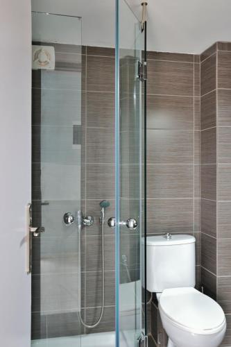 a bathroom with a toilet and a glass shower at Katerina Apartments in Kato Daratso