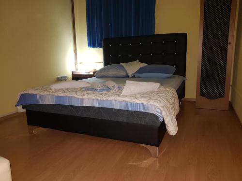 a bed with a black headboard in a bedroom at Motel Magistrala in Doboj