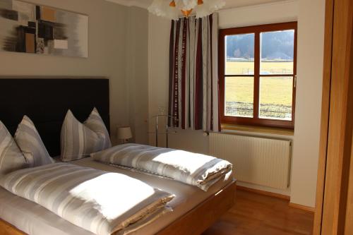 1 dormitorio con 1 cama con 2 almohadas en Ferienwohnungen Kolbitsch, en Greifenburg