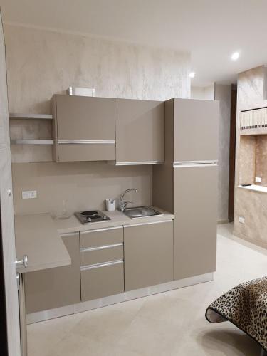 a small kitchen with white cabinets and a sink at Le Cale' B&B in San Severo