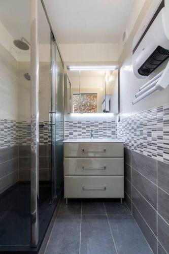 une salle de bain avec une douche, un lavabo et un miroir dans l'établissement ❤️ Charmant appart ancien rénové place des Carmes, à Toulouse