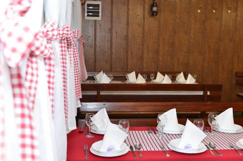 a table with a red table cloth and white napkins at Apartmani Miščević in Josipdol