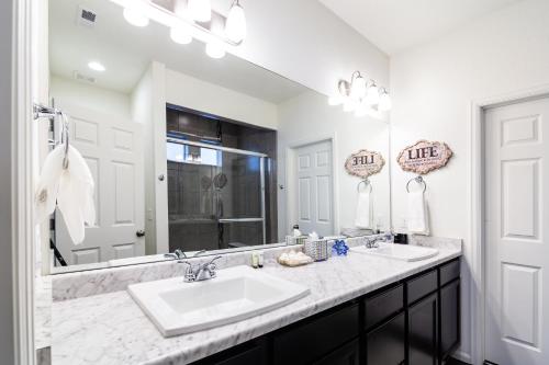a bathroom with two sinks and a large mirror at Den Haven Entire Home Near DIA With Three Bedrooms And Private En Suite Baths in Denver
