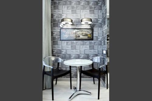 a table and chairs in a room with a brick wall at Beach & Beatles Apartments in Odesa