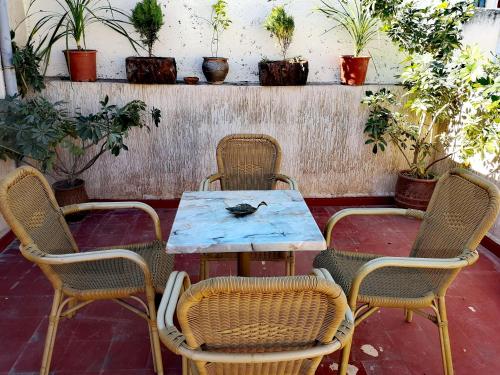 une table et quatre chaises avec une table et des plantes dans l'établissement Adam's House- Fes City, à Fès