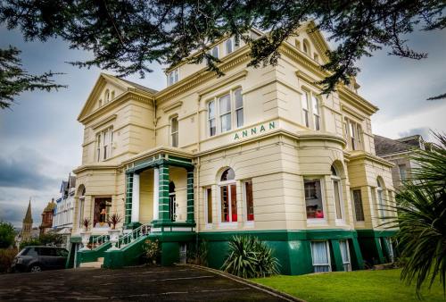a large yellow building with a green trim at The Annan Hotel in Llandudno