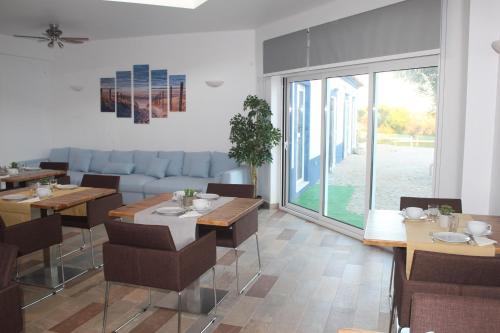 a dining room with tables and chairs and a large window at Monte das Perdizes in Olhão
