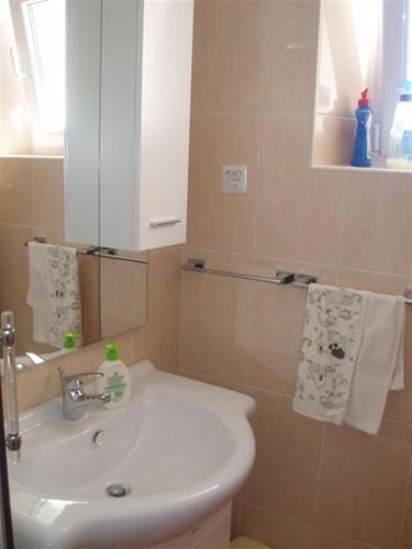 a bathroom with a white sink and a mirror at Apartments Seka in Hvar