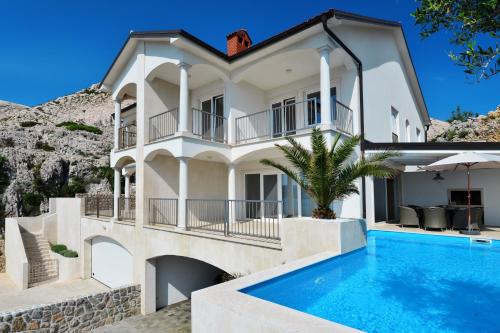 a large white house with a swimming pool in front of it at Villa Mar - Only 50m To The Beach in Stara Baška