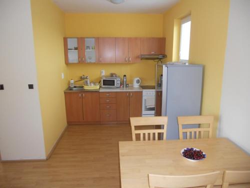 a kitchen with a table and chairs and a refrigerator at Penzion Kaplna in Kaplna