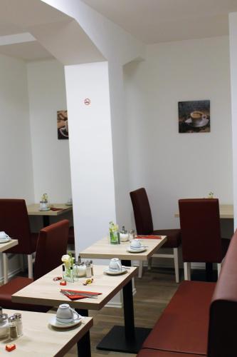 a dining room with two tables and chairs at Pionier Hotel Hamburg Wandsbek in Hamburg