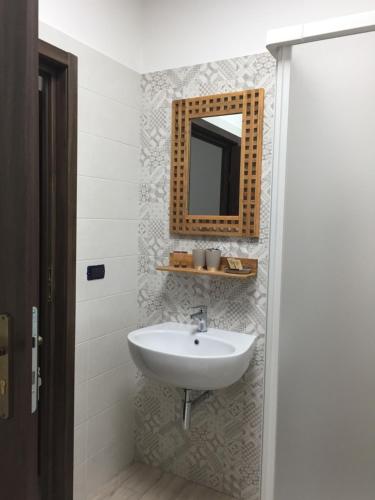 a bathroom with a sink and a mirror on the wall at Dely B&B in Arquata Scrivia