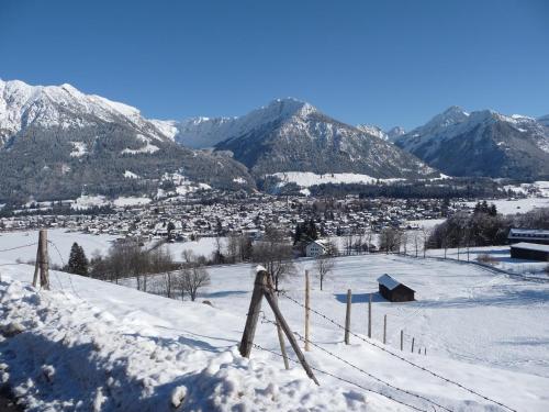 a snow covered valley with a town and mountains at Gästehaus Schmid in Obermaiselstein