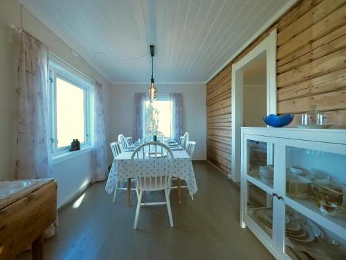 ein Esszimmer mit einem weißen Tisch und Stühlen in der Unterkunft Atlantic View Lofoten in Bøstad