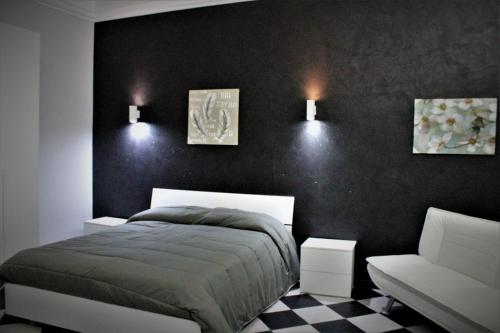 - une chambre avec un lit et un mur noir dans l'établissement Il cortiletto, à Ravanusa