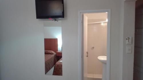 a bathroom with a sink and a television on a wall at Hotel Caribe in Mar del Plata
