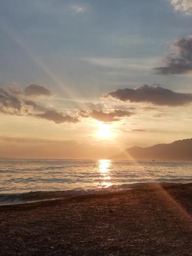 a sunset on a beach with the ocean at Apartment Baška Voda-Croatia in Baška Voda