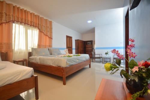a bedroom with a bed and a table at White Summerville Tourist Inn in Busuanga