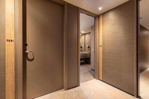 a hallway with a door leading to a bathroom at Novotel Melbourne Central in Melbourne