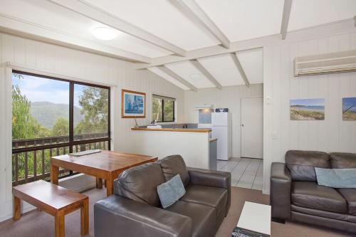 a living room with a couch and a table at Beacon Point Ocean View Villas in Apollo Bay