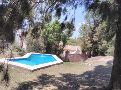 ein Pool im Garten mit einem Baum in der Unterkunft Casa en Playa Perelli in Villa Carlos Paz
