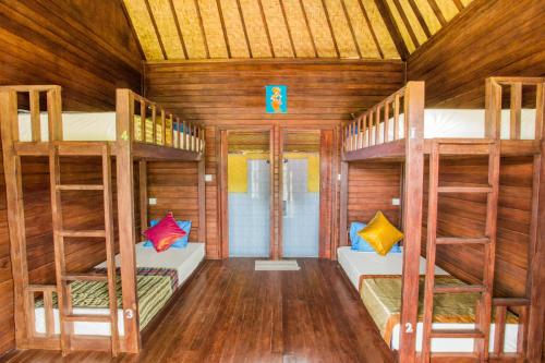a room with bunk beds in a wooden room at Uma Hostel Lembongan in Nusa Lembongan
