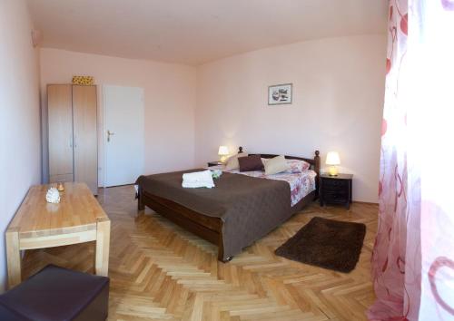 a bedroom with a bed and a table in it at Apartments Beautiful Sandy Beach in Split
