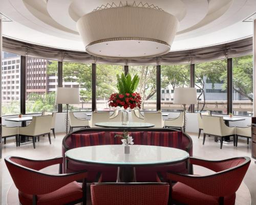 a restaurant with tables and chairs and a large chandelier at Shangri-La Kuala Lumpur in Kuala Lumpur