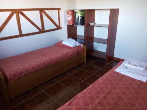 Habitación pequeña con 2 camas y ventana en Mi Refugio en Río Gallegos