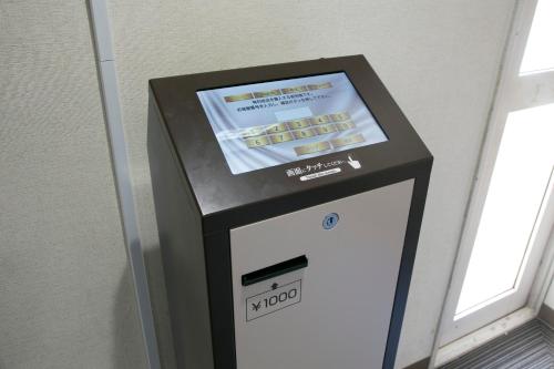 a ticket machine in a room with a window at Hotel S-Plus Hiroshima Peace Park in Hiroshima