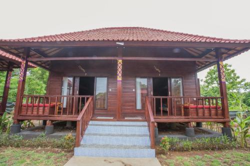 a wooden house with a staircase leading to it at Uma Hostel Lembongan in Nusa Lembongan
