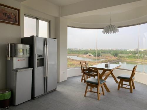 uma cozinha com um frigorífico e uma mesa com cadeiras em White Hunter B&B em Tainan