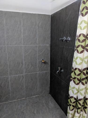a bathroom with a shower with a shower curtain at Florence Cottage in Beddegama