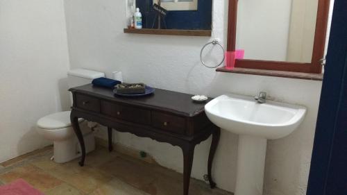 uma casa de banho com um lavatório, um WC e um espelho. em Casas dos Sonhos em Paraty