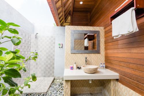 ein Badezimmer mit Waschbecken und Dusche in der Unterkunft Dream Beach Cottages in Nusa Lembongan