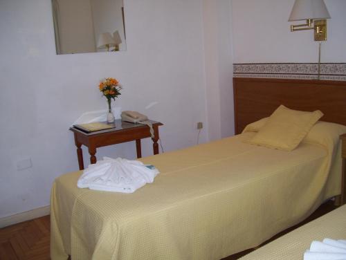 a bedroom with two beds and a table with a phone at Apolo Atlantis in Mar del Plata
