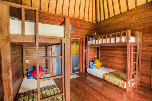 レンボンガン島にあるUma Hostel Lembonganの木製の壁の客室で、二段ベッド2組が備わります。
