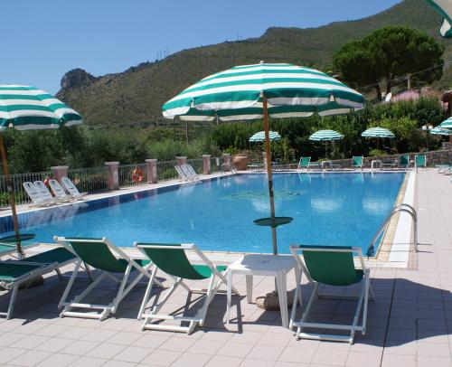 a pool with chairs and a table with an umbrella at Hotel Ristorante Borgo La Tana in Maratea