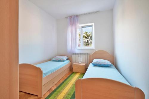 a bedroom with two beds and a window at Apartments Rajic in Poreč