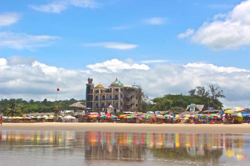 a beach with umbrellas in front of a building at Dharma Beach in Montañita
