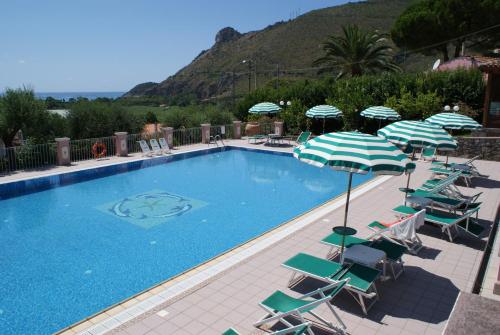 a swimming pool with lawn chairs and umbrellas at Hotel Ristorante Borgo La Tana in Maratea