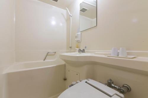 a white bathroom with a sink and a toilet at Hotel S-Plus Hiroshima Peace Park in Hiroshima